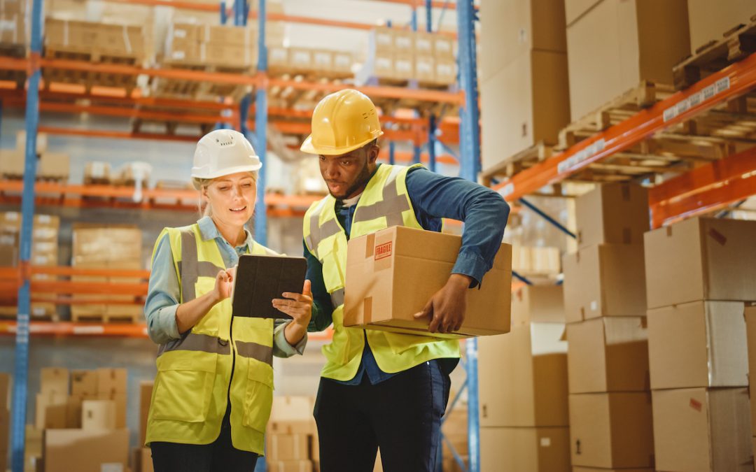 Woman and man in warehouse looking at an ipad